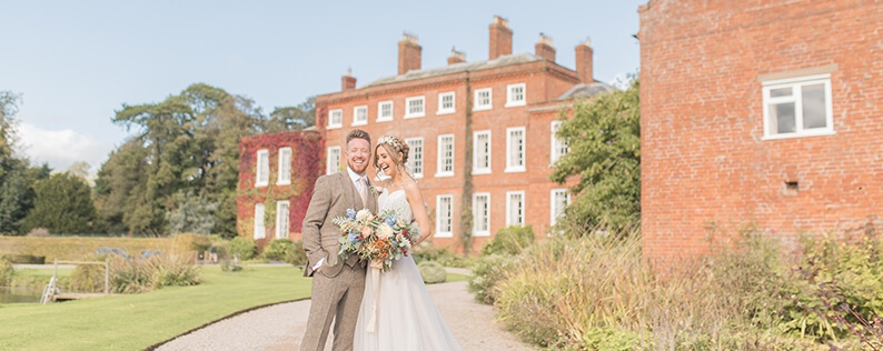 The happy couple pose for a wedding photo at Delbury Hall wedding venue in Shropshire