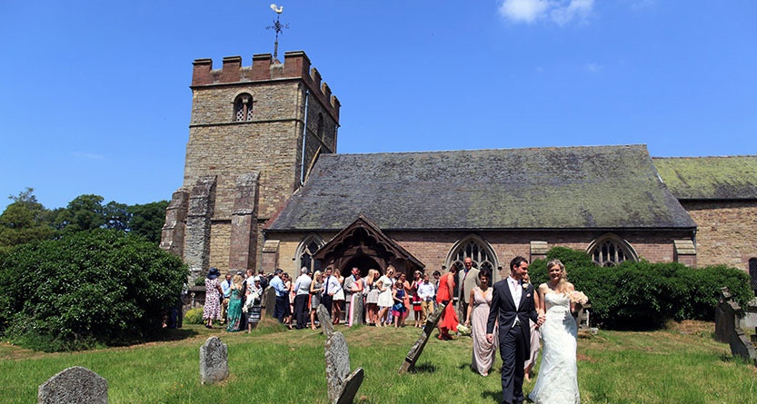 Bride, groom and guests in front of St Peter's Church wedding venue Worcester